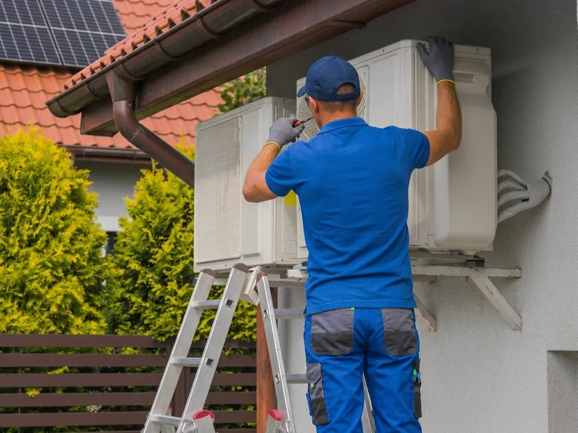 Tecnico durante l'installazione di una pompa di calore esterna