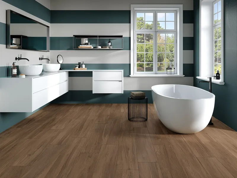 Bagno con piastrelle verde bosco e rubinetteria in finitura opaca